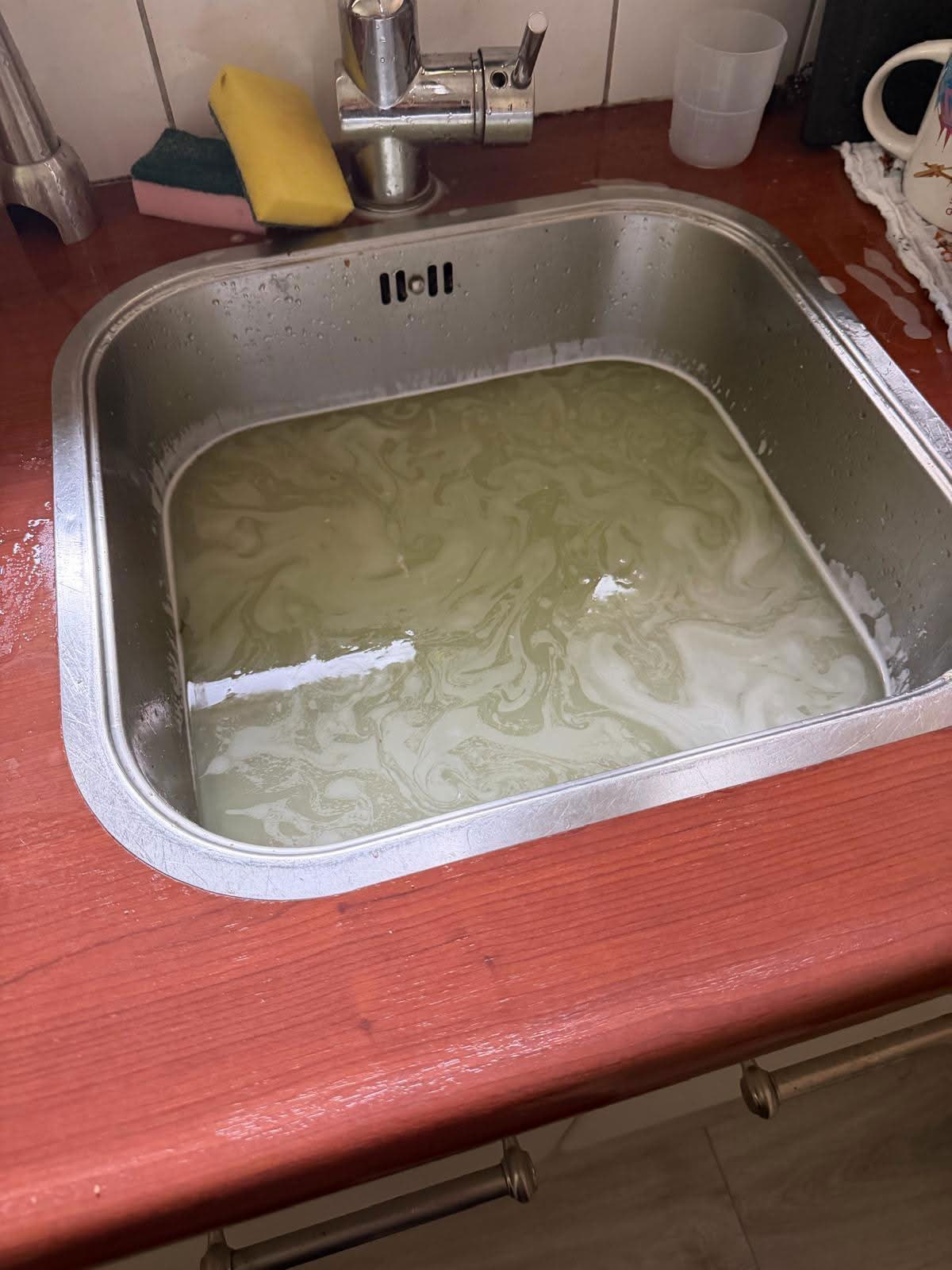 Verstopte gootsteen met water dat blijft staan